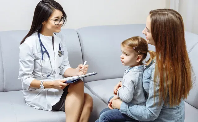 Pediatric Nurse Practitioner Smiling with Patient in Exam